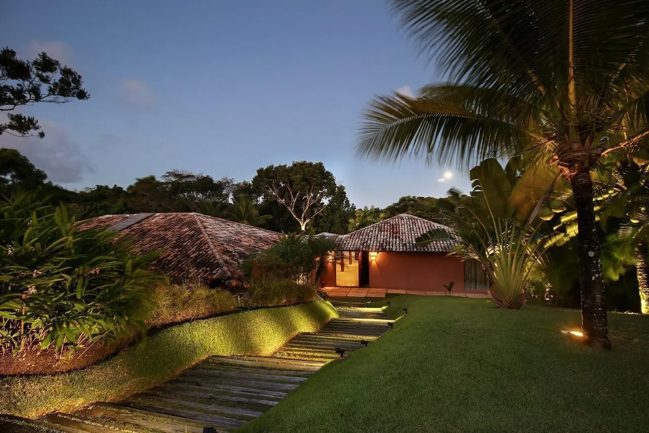 Casa 21 - jardim iluminado ao anoitecer, com a casa ao fundo