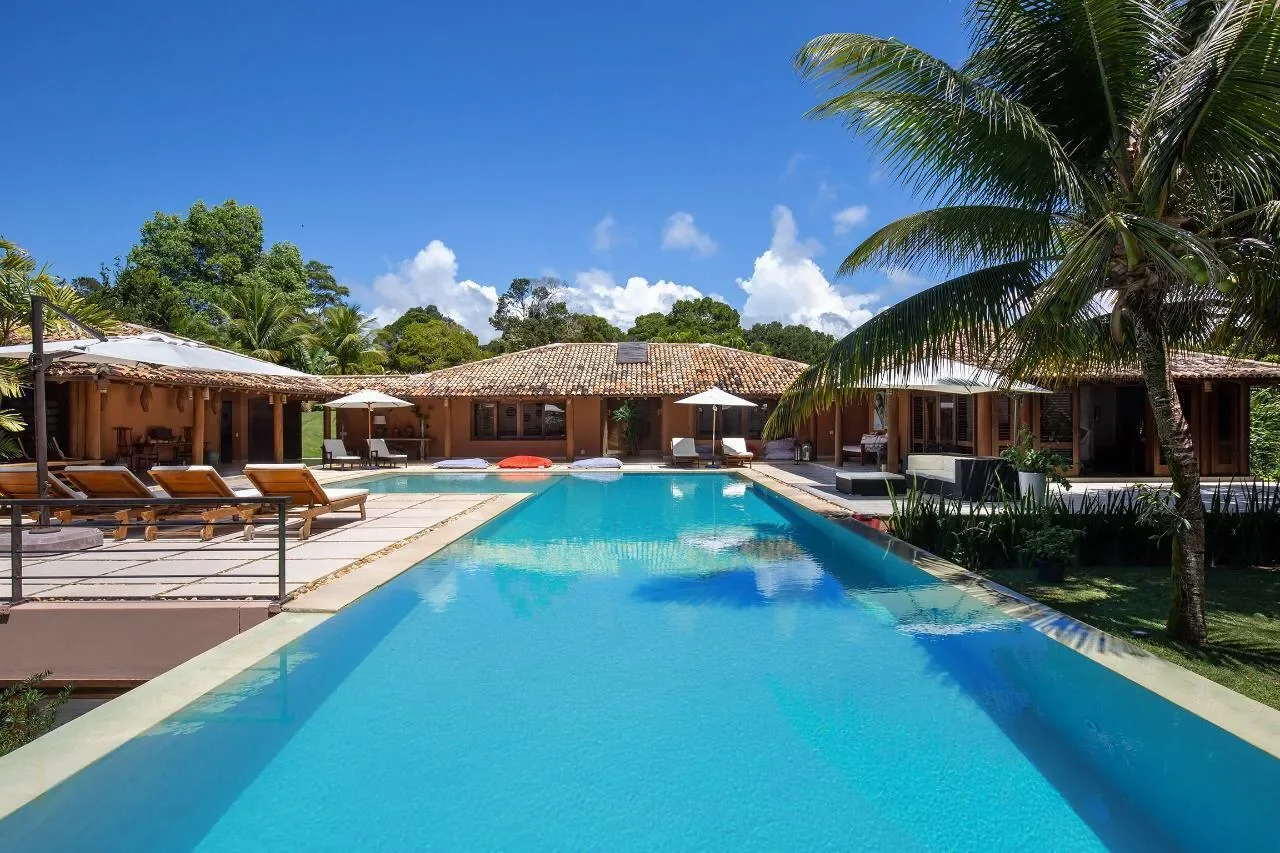 Casa 21 - piscina de dia com a casa e a mata ao fundo