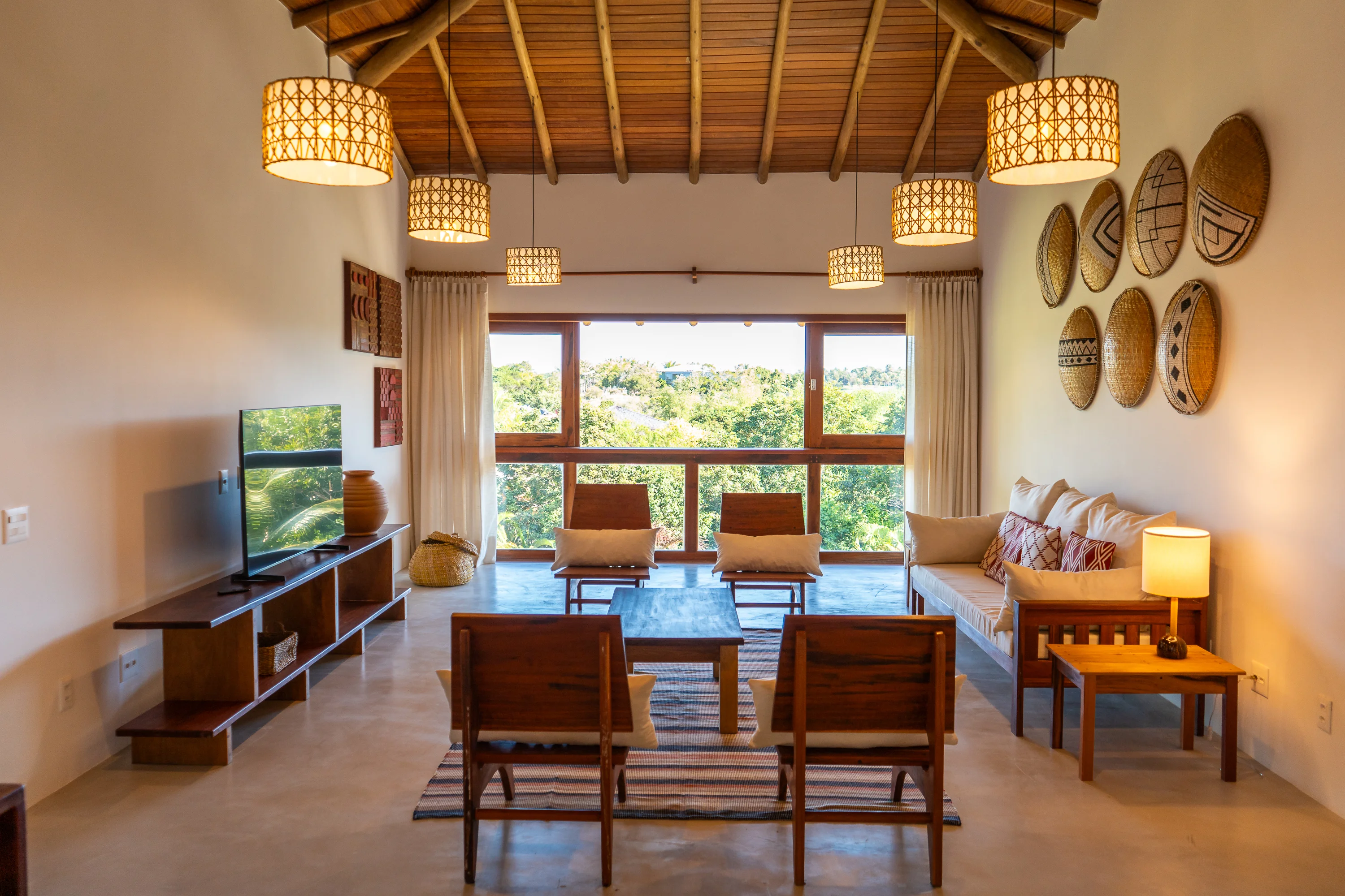 Casa 21 - Wohnzimmer mit Fernseher, Sofa und großen Fenstern mit Blick auf den Garten