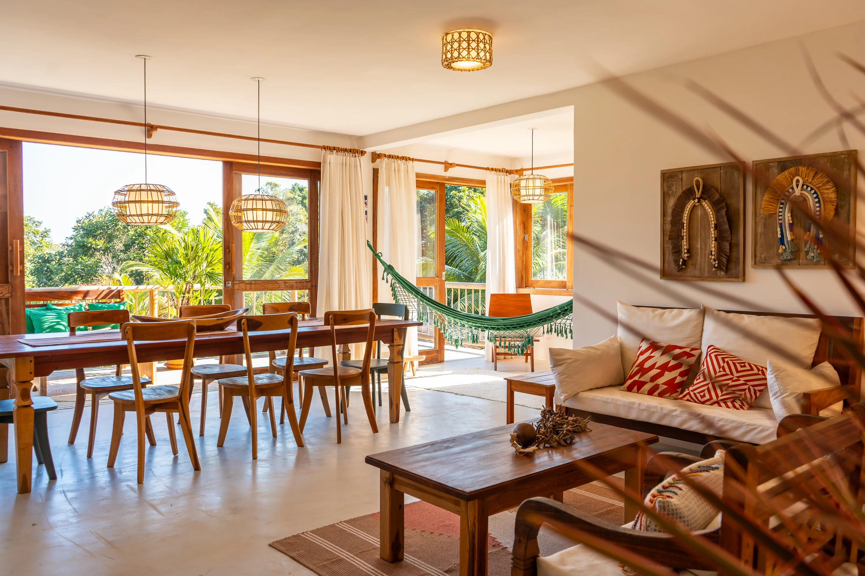 Casa 21 - mit dem Wohnzimmer integriertes Esszimmer mit Hängematte, Sofa und großen Fenstern