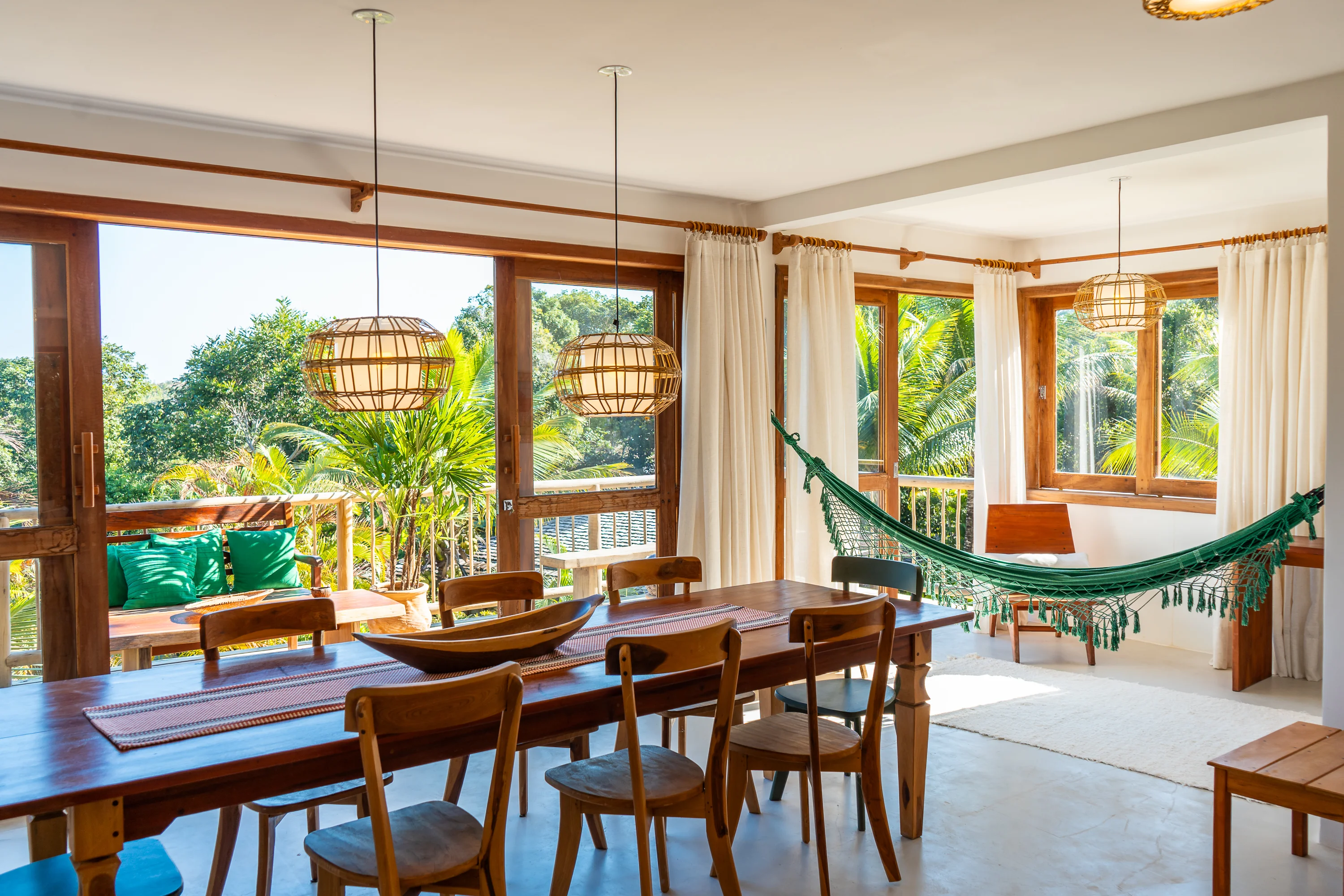 Casa 21 - Esszimmer mit großem Tisch, Hängematte und Fenstern zum Balkon und Garten