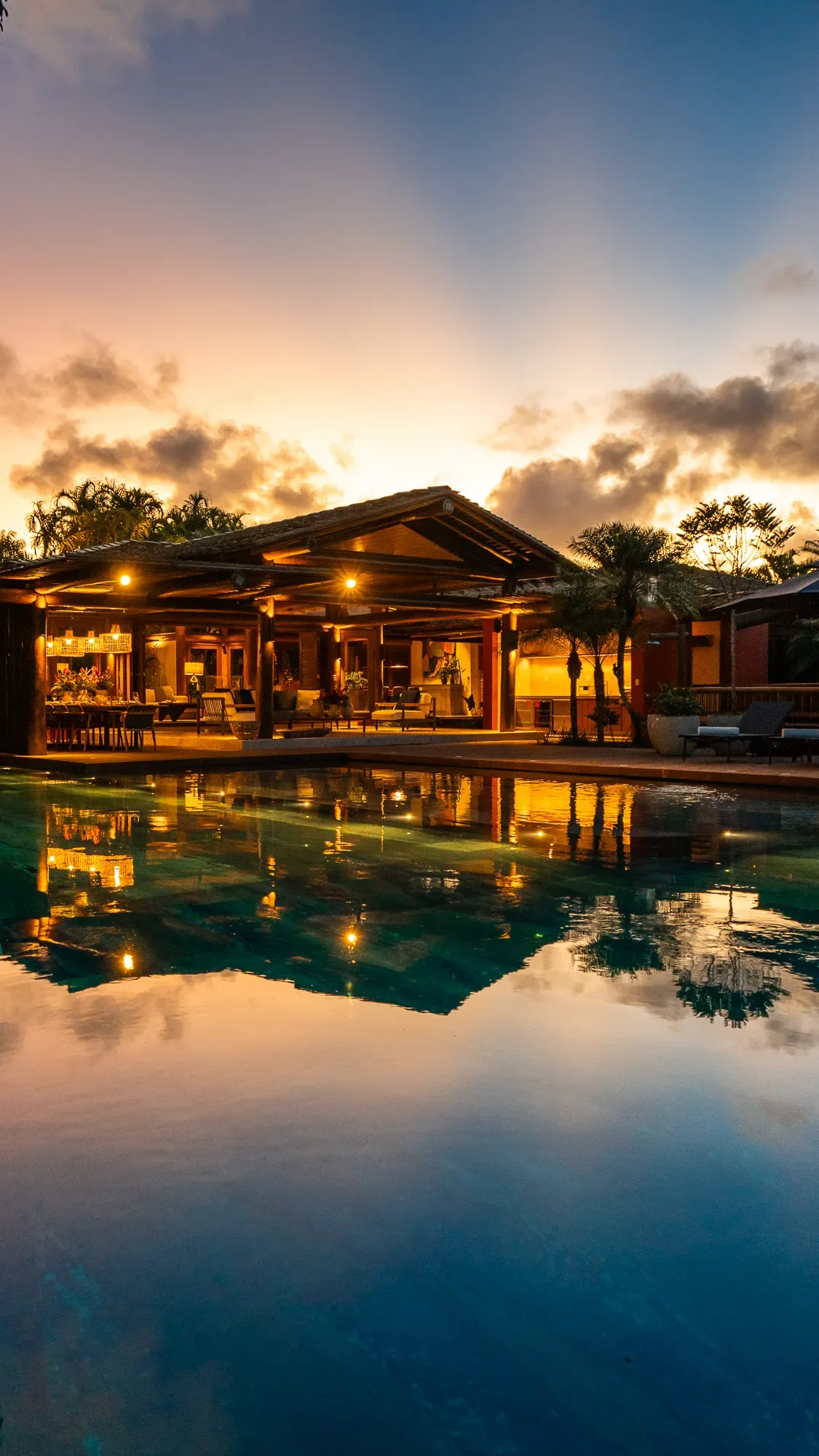 Casa 62 - pavilhão iluminado refletido na piscina ao entardecer