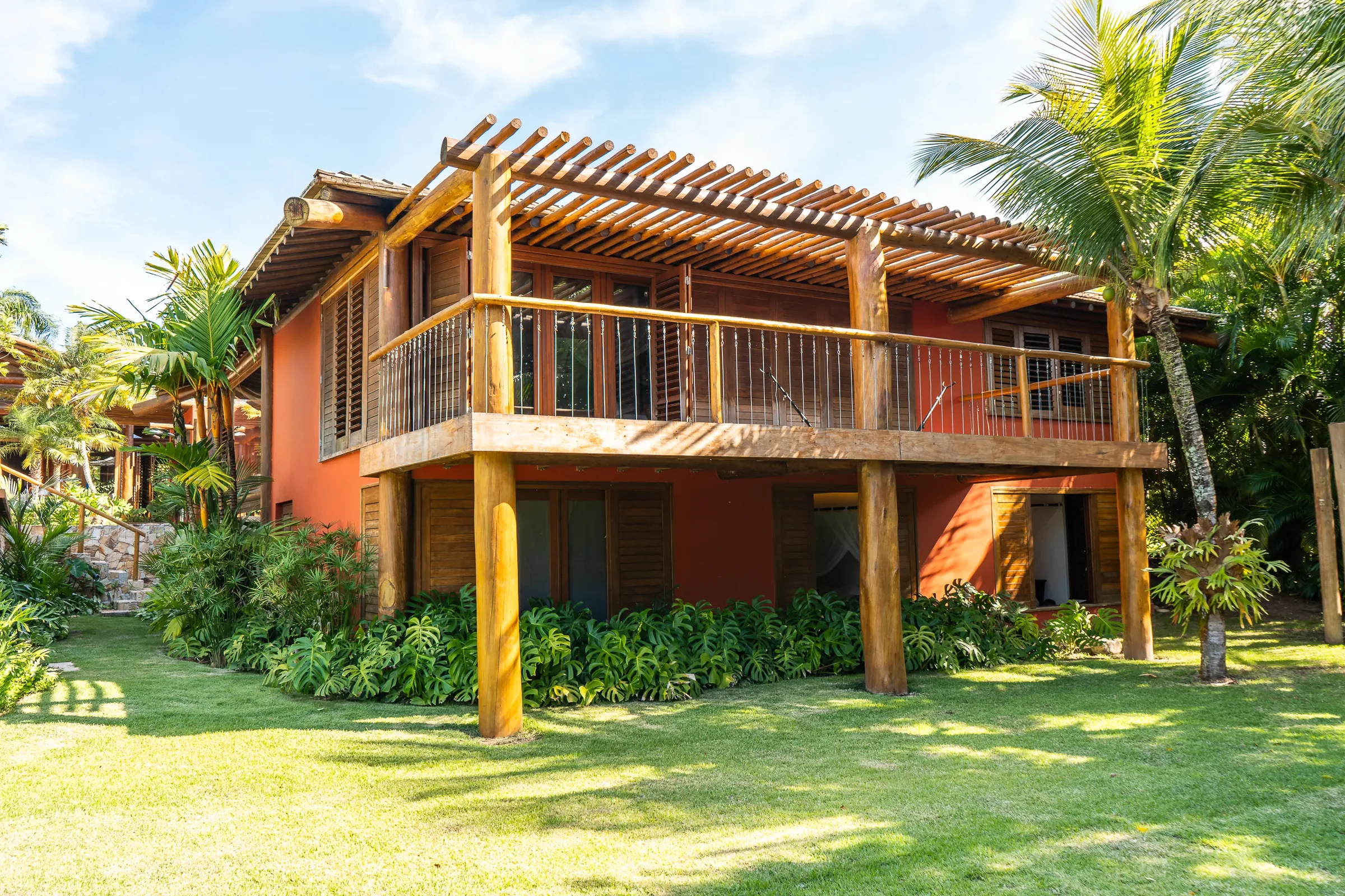 Casa 62 - fachada da casa principal em terracota com varanda de madeira