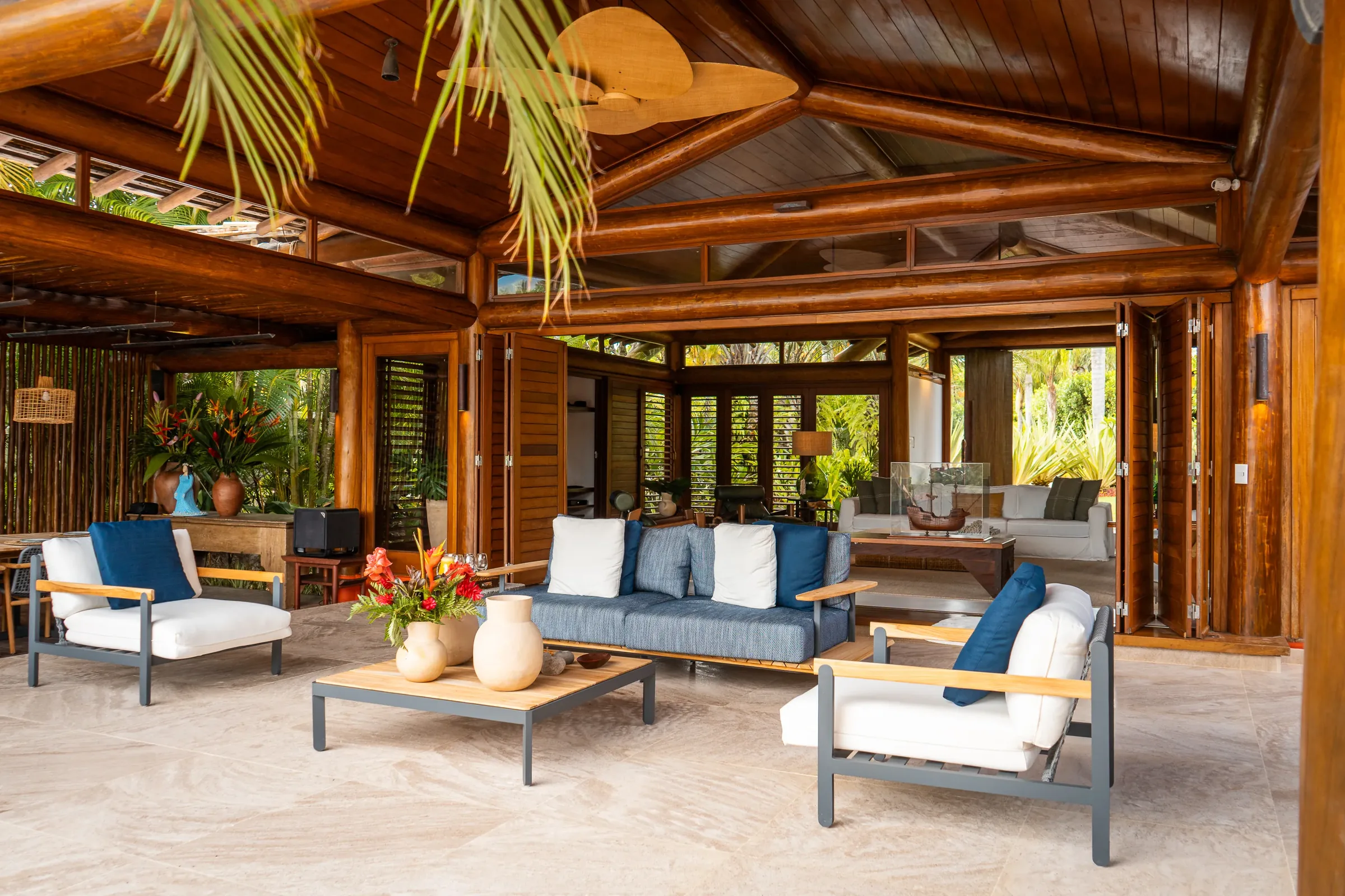 Casa 62 - estar externo coberto com sofás e vista para o jardim
