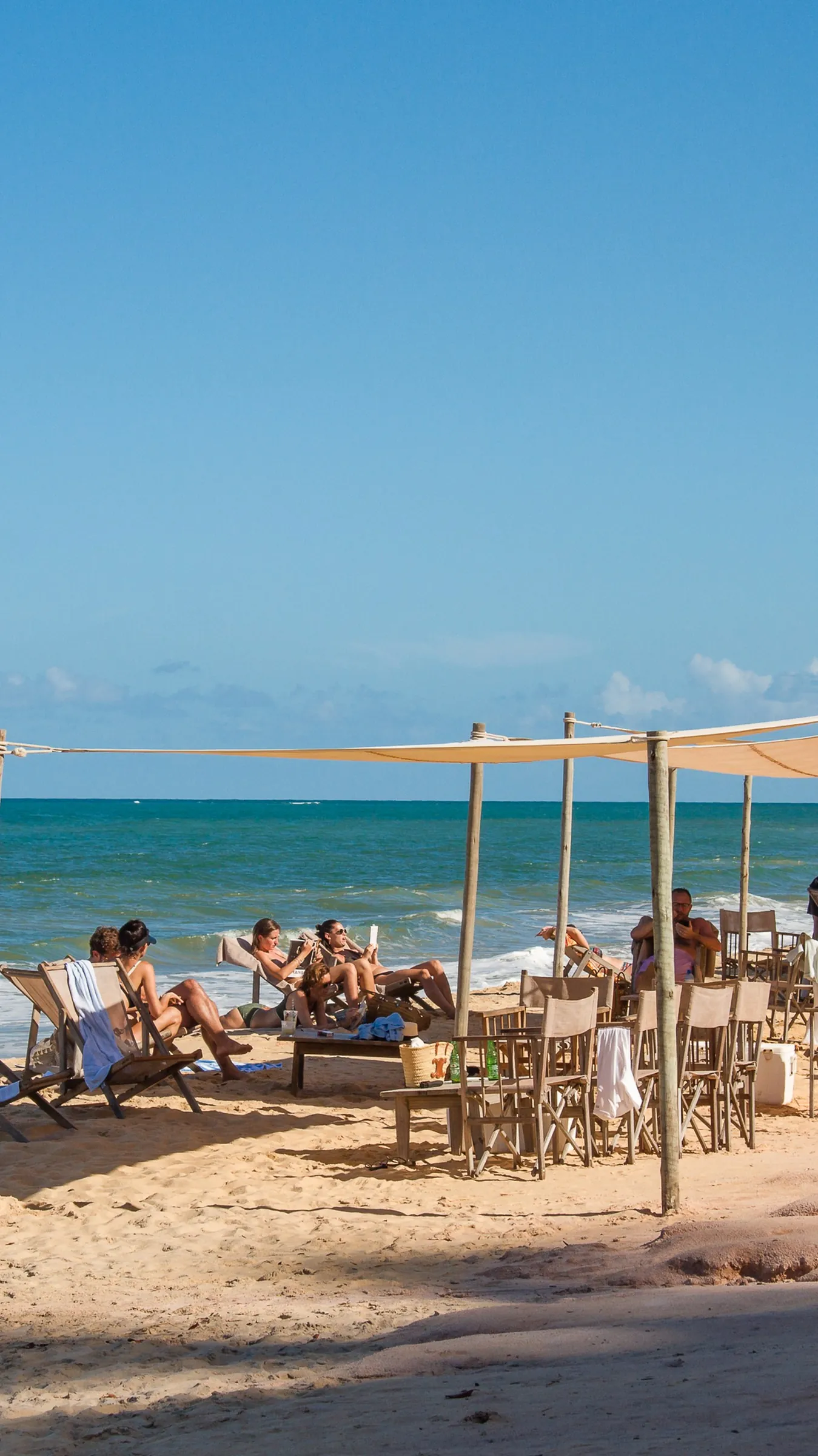 Guarda-sóis e espreguiçadeiras na areia da Praia das Tartarugas